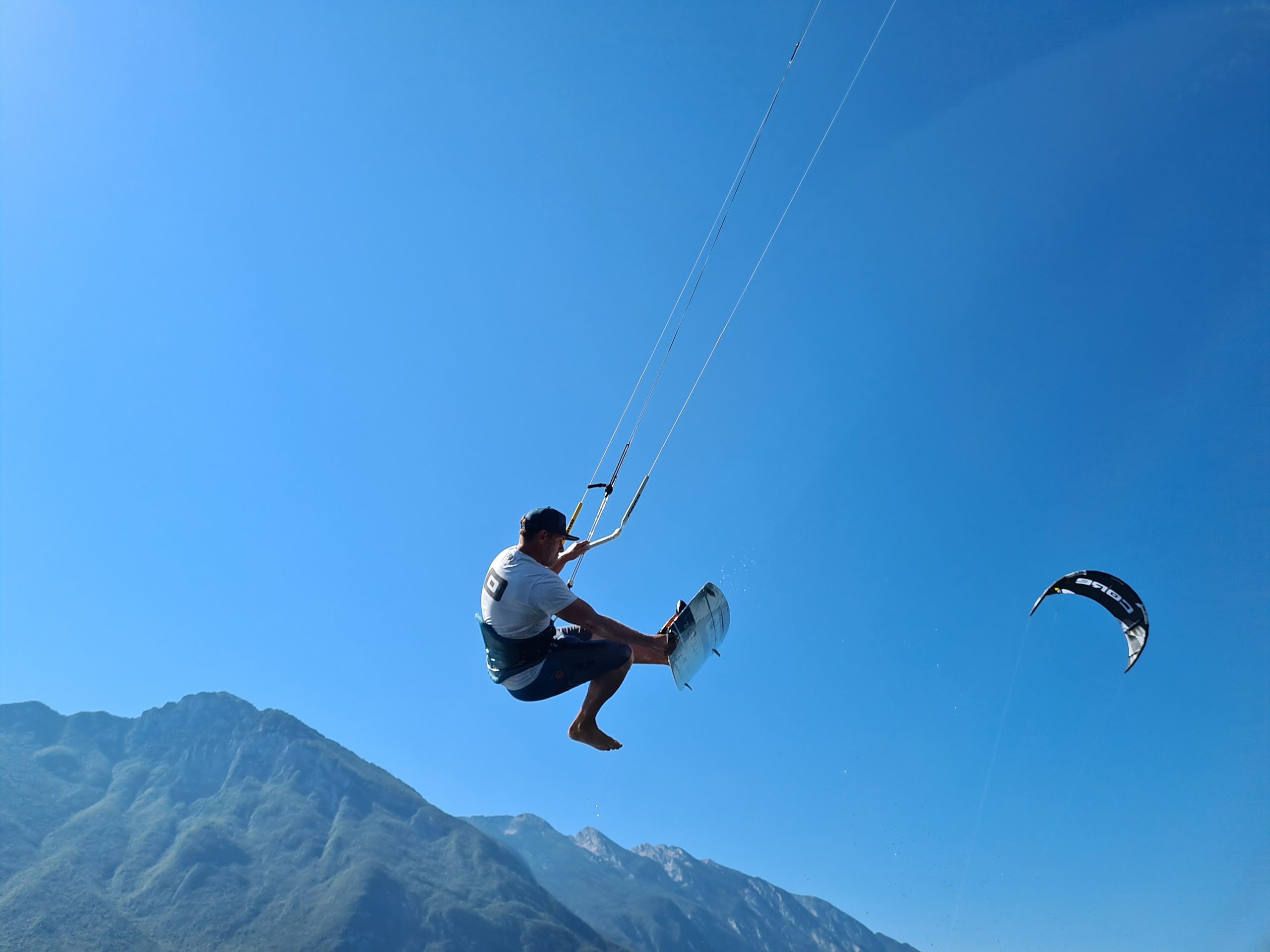hoge kitesurf sprong met board off op het Gardameer